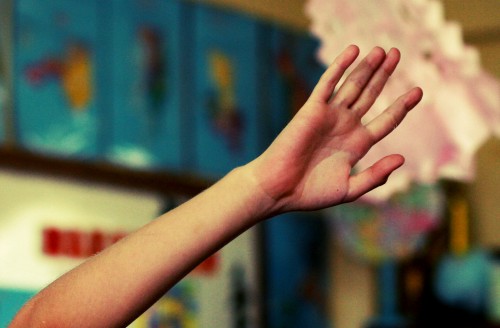 student raising his hand in math class